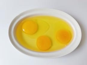 把三个鸡蛋磕入碗里。