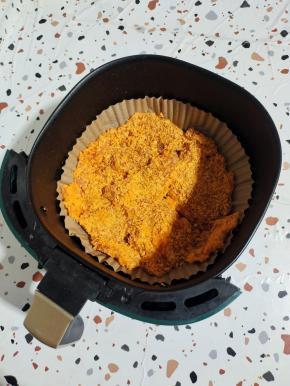 空气炸锅铺一张吸油纸，再喷适量的油，把裹好面包糠的鸡胸肉放入空气炸锅中！