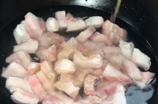 将五花肉放入冷水锅中，加入料酒，中火煮沸至变色
