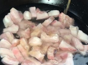 将五花肉放入冷水锅中，加入料酒，中火煮沸至变色