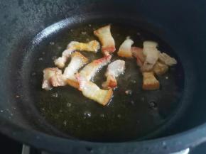 另起锅加少许油，加入腊肉煸炒出油，