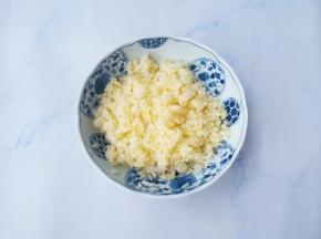 冰箱冷冻了一晚的米饭取出，打入一个鸡蛋黄，搅拌均匀，使每一粒饭米上都能均匀裏上蛋液。