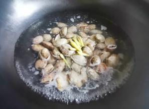 锅中烧开水，加1勺料酒，放入花甲煮到开口，连水一起盛出，放一边备用。