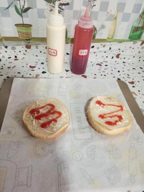 汉堡上挤适量的沙拉酱和番茄酱！