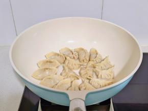 锅中喷油摆入饺子。