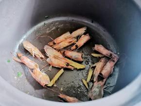 锅中油热，放葱段煸香，加入虾头炒出虾油，