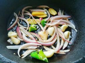 另起锅热油下入洋葱、姜片和大蒜炒香，