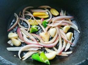 另起锅热油下入洋葱、姜片和大蒜炒香，
