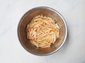 莲藕去皮切成2cm左右的长条，用凉水加一点白醋浸泡，防止变色。