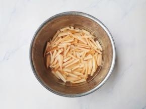 莲藕去皮切成2cm左右的长条，用凉水加一点白醋浸泡，防止变色。