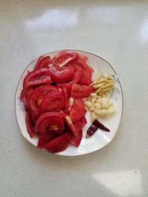 西红柿清洗干净切成块，蒜瓣切成小块，生姜切成丝，干辣椒切成段备用！