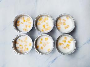 锡纸碗中放入芒果肉，倒入调好的钵仔粉浆至6成满，