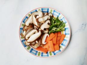 香菇洗净切片，胡萝卜去皮切片，辣椒切条。