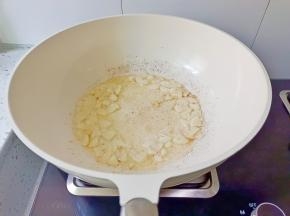 锅里留一点底油，放入蒜片炒香