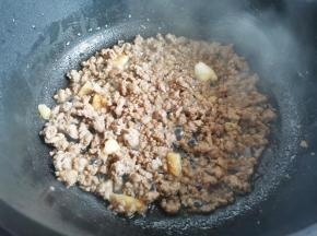 另起锅热油，爆香大蒜，加入肉末炒至变色盛出备用。