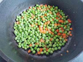 起锅热油，放入豌豆和胡萝卜炒干水分，