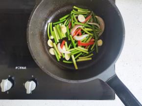 加入红椒炒匀，加蒜苔炒至变色，