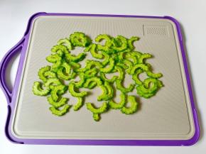 苦瓜对半切开，用勺子把里面的瓤刮干净 ，切成薄片