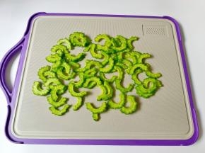 苦瓜对半切开，用勺子把里面的瓤刮干净 ，切成薄片