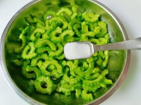 加一勺盐，用手抓拌均匀腌制五分钟，五分钟后用手把苦瓜挤干，再用清水多冲洗几遍，沥干水分