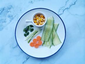 玉米粒煮熟，黄瓜刨4片，剩下的剪出叶子和茎，胡萝卜用模具做出小圆，中间划十字花刀。