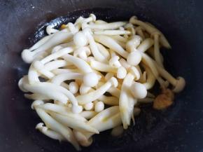 锅中热油，爆香大蒜，放入菌菇煸炒出水分，