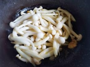 锅中热油，爆香大蒜，放入菌菇煸炒出水分，