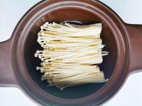 砂锅中放入金针菇，