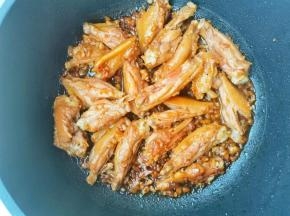 锅中热油，鸡翅小火煎至金黄，放入腌制鸡翅的酱汁，炒出香味，