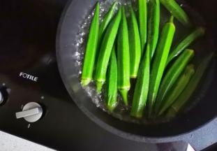 秋葵去蒂盐水浸泡洗净，锅中水开，加一丟丟油和盐，再放入秋葵煮1分钟捞出过凉备用。