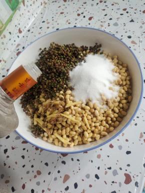 处理好的黄豆倒入大盆里，再放入姜丝，盐，新鲜花椒，再倒入适量的高度白酒！