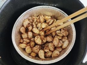 用筷子翻拌均匀！如果蒜瓣太干巴，可以再喷适量的油，再翻拌！