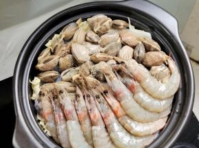 再把处理好的花甲和基围虾摆放在砂锅里！