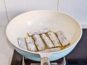锅中热油摆入带鱼。（煎带鱼不碎的小窍门，带鱼刚放入锅中时不要去碰它，待底部简直定型，金黄后再翻面，这样做出来的带鱼很完整哦）