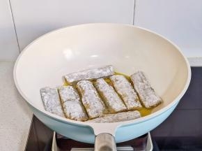 锅中热油摆入带鱼。（煎带鱼不碎的小窍门，带鱼刚放入锅中时不要去碰它，待底部简直定型，金黄后再翻面，这样做出来的带鱼很完整哦）