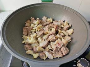 锅里加葱段，香叶，大料炒香，加牛肉粒翻炒两分钟