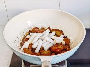 加入年糕翻炒，均匀裹上酱汁。