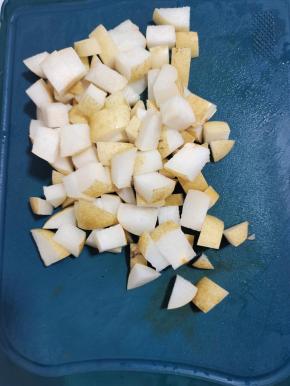 清洗好的雪梨放在案板上，先对半切开！这个蒂不要的先切掉！再改刀切成小块！切完后把它翻个面，挑选出带核的部分，把核切掉就可以了！很多人炖雪梨喜欢把皮削掉，其实这样做是错误的！这是最精华的一部分，止咳最重要的部分就是皮！所以不要觉得前面清洗部分很麻烦！