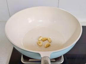 起油锅加入蒜瓣煎至焦黄。