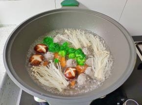 锅里水开，下牛肉丸，香菇，金针菇，西蓝花胡萝卜煮熟捞出备用。