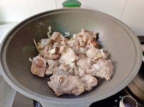 放入焯水后的筒骨炒至两面微黄