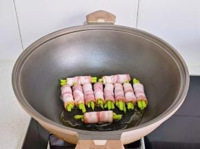 锅中喷油，摆入培根芦笋卷。