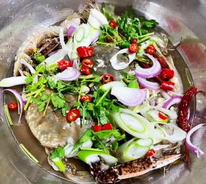 处理好的螃蟹和虾爬子放入容器中，倒入晾好的调料水，放入切好的配料。