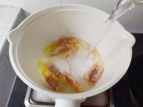 炒出虾油，加入开水，水开煮五分钟后把虾头捞出