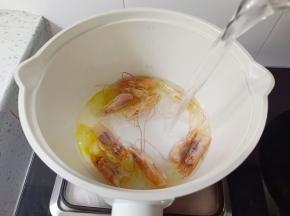 炒出虾油，加入开水，水开煮五分钟后把虾头捞出