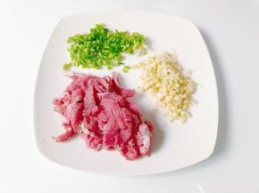 牛肉切成细丝，葱蒜切成末。