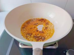 锅里放入蒜末，辣椒酱炒出红油