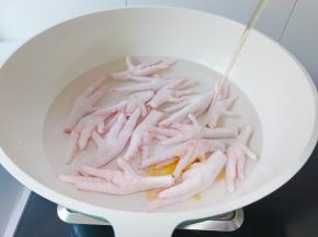 鸡爪剪掉指甲，冷水放入锅里，加入料酒