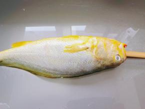 用筷子分别压住黄鱼两边是鱼鳃，把筷子往肚子里放，然后筷子转圈，轻轻往外拉，就可以去除内脏，保证鱼的完整性