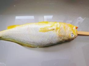 用筷子分别压住黄鱼两边是鱼鳃，把筷子往肚子里放，然后筷子转圈，轻轻往外拉，就可以去除内脏，保证鱼的完整性